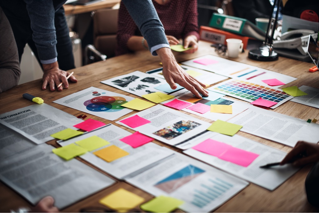 Equipo planificando una estrategia con notas y documentos sobre la mesa