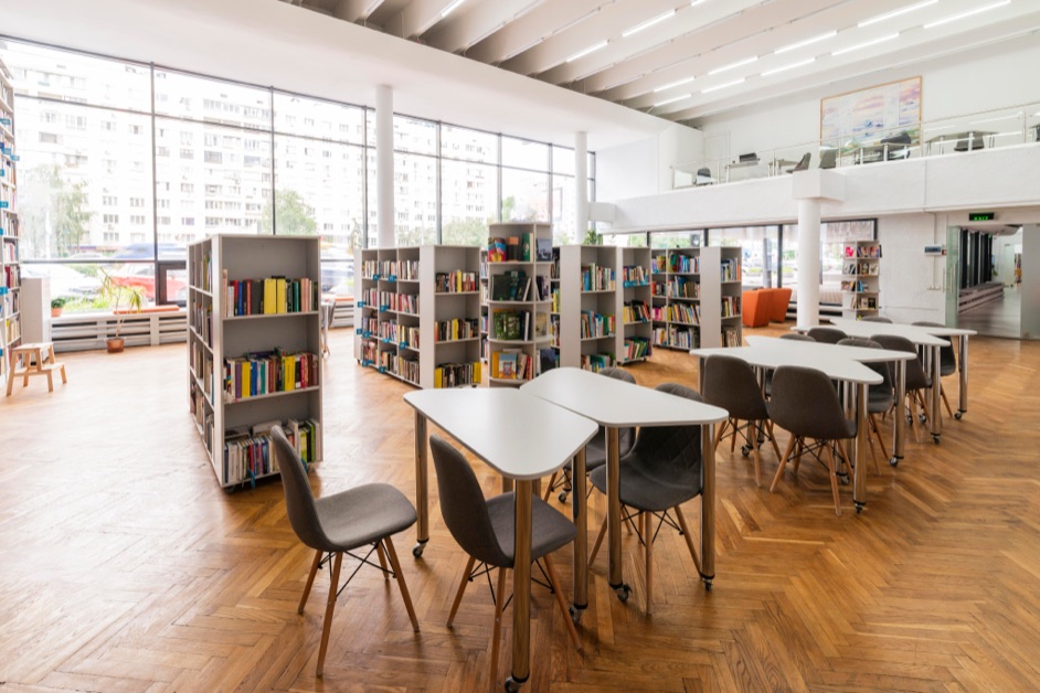 Biblioteca moderna con mesas y estanterías