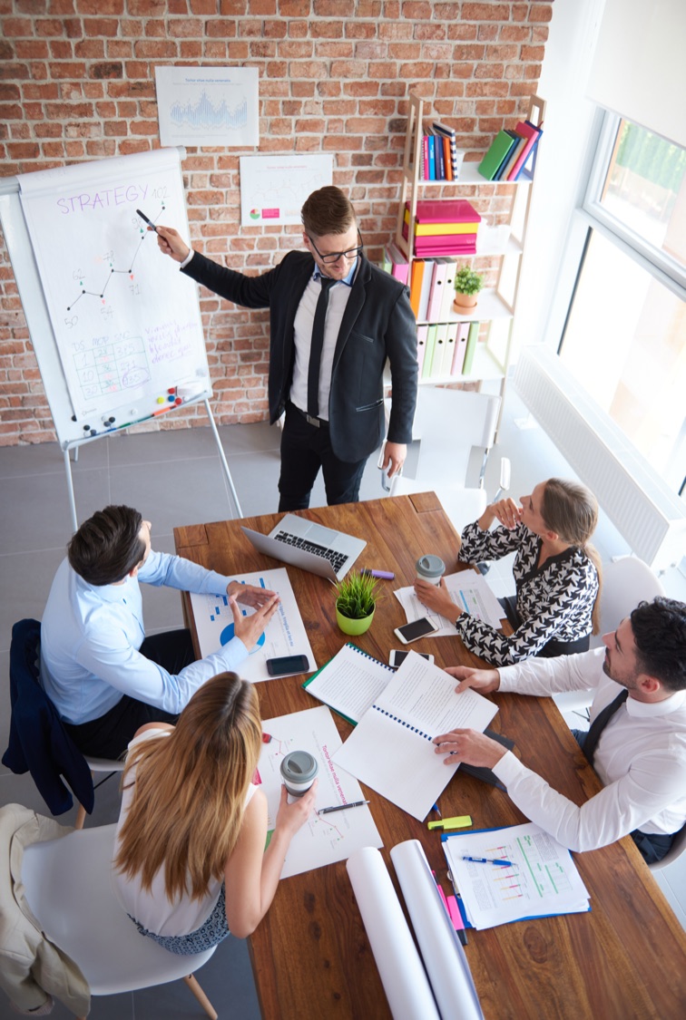 Consultor presentando una estrategia a un equipo de trabajo